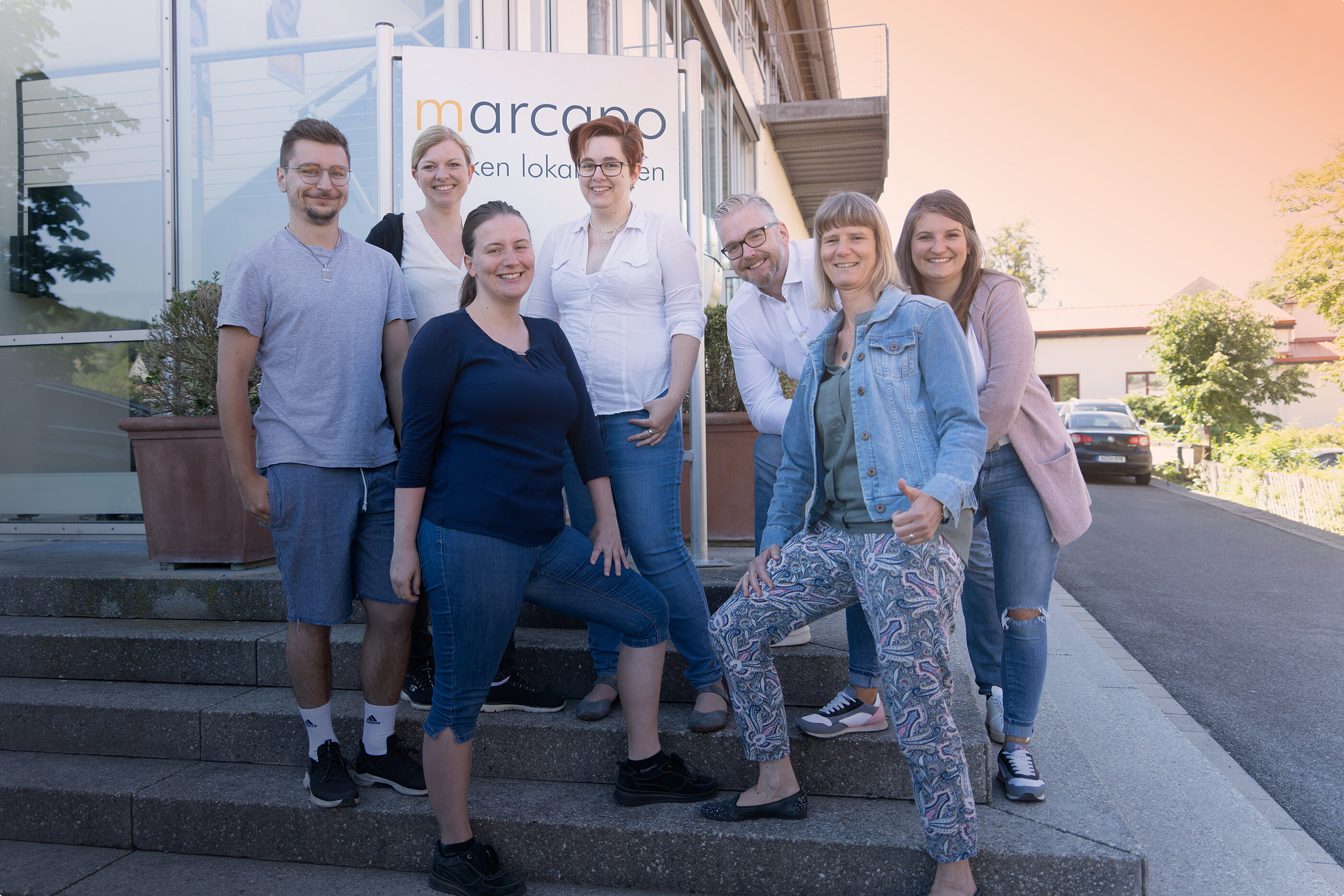 Das marcapo Finance-Team steht vor dem Eingang des Firmengebäudes