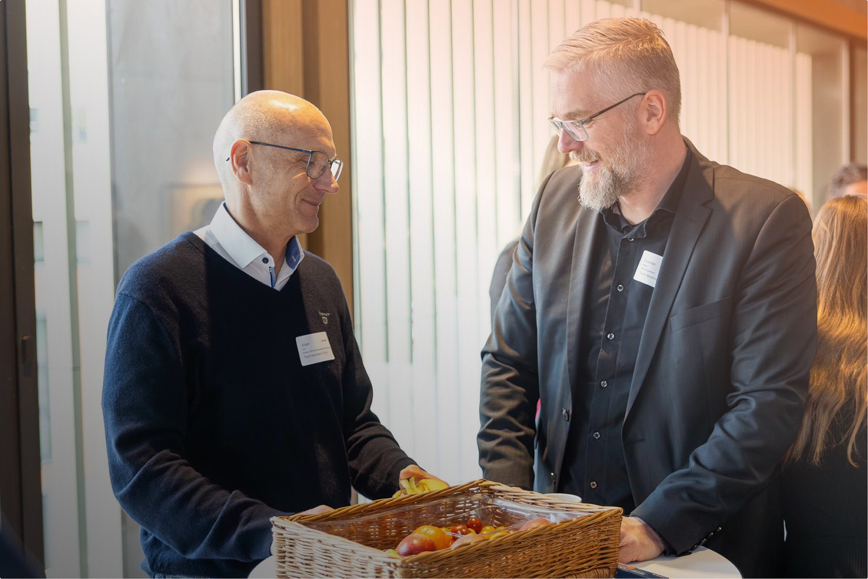 Zwei Männer unterhalten sich locker an einem Stehtisch stehend