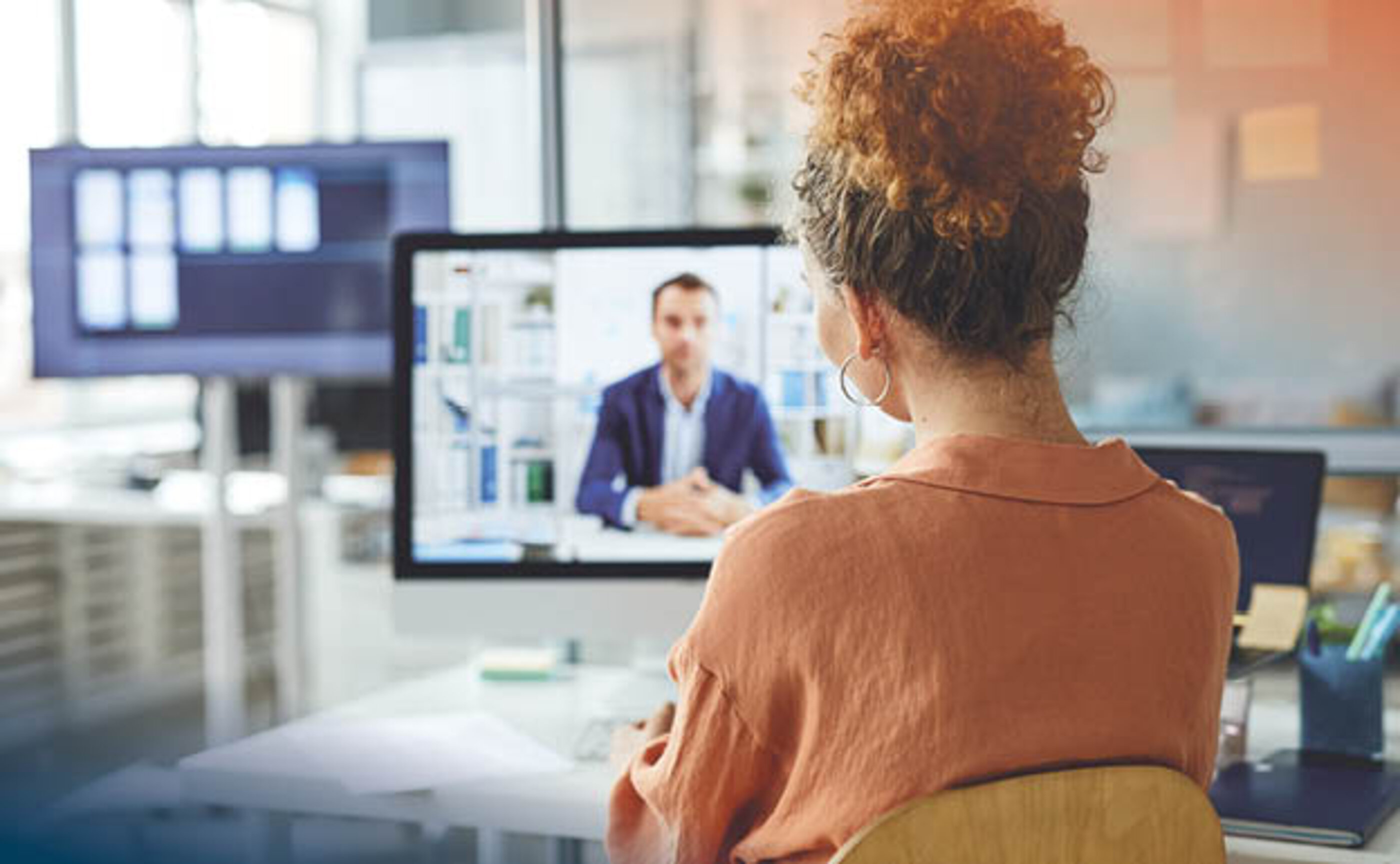 A young woman is looking at a computer screen