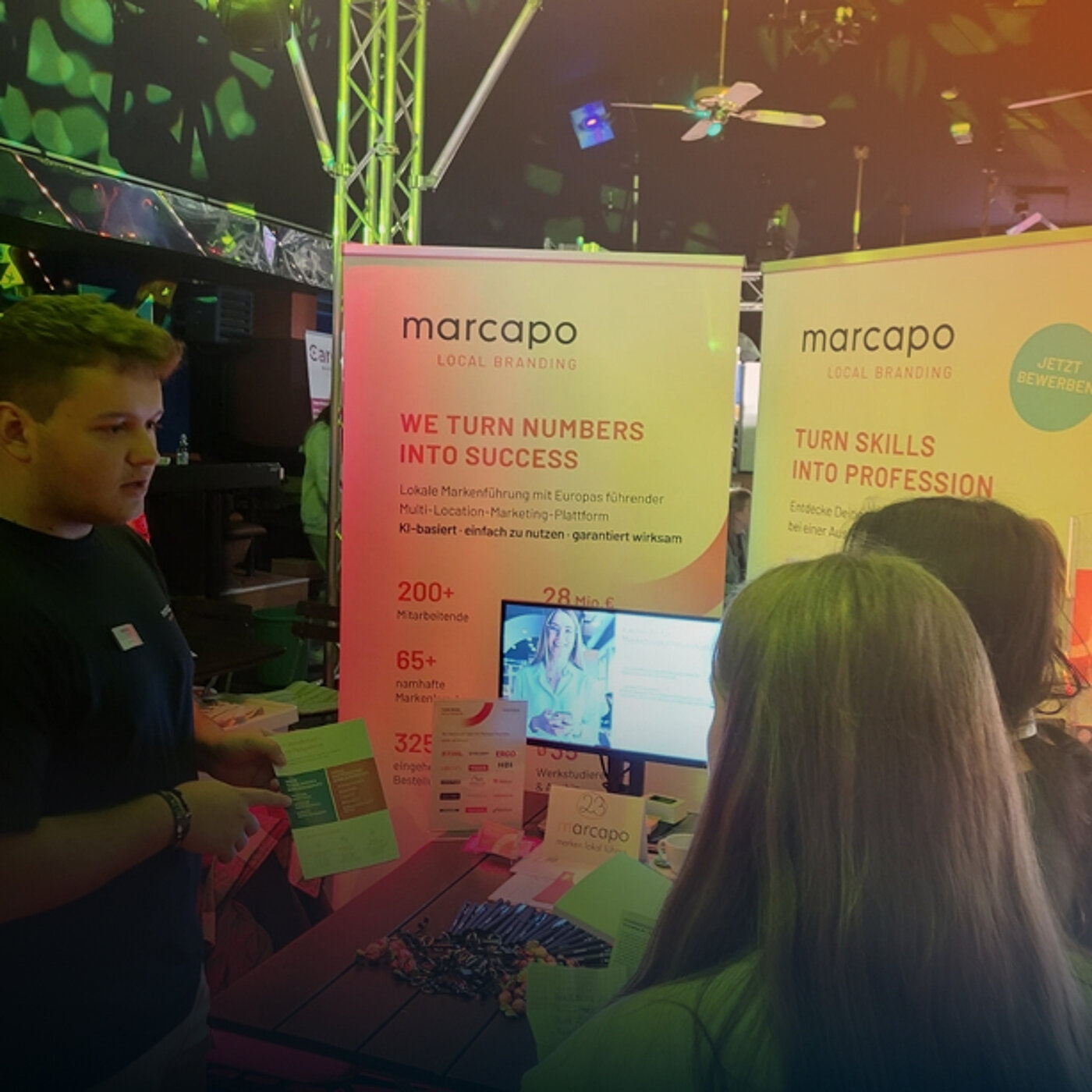 Ein Azubi spricht mit Interessenten bei einer Azubi-Messe