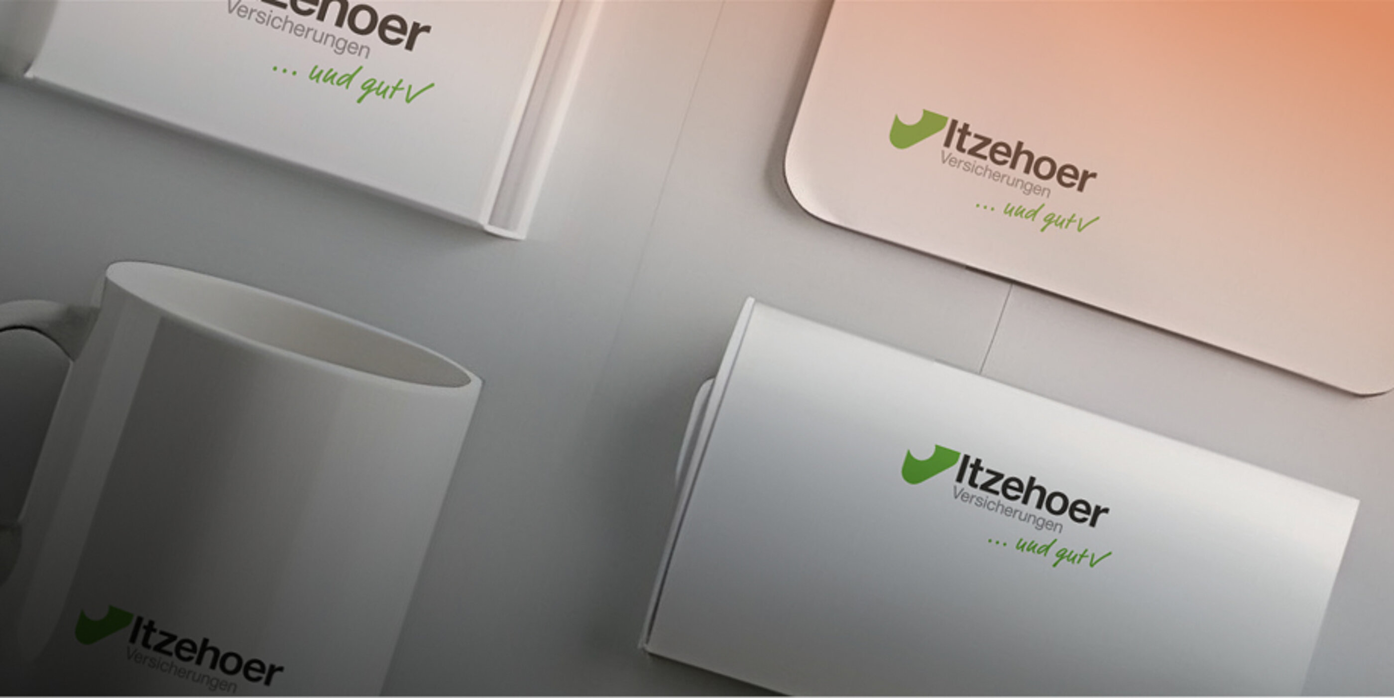 Werbemittel mit Logo der Itzehoer Versicherungen auf Tasse, Broschüre und weiteren Drucksachen