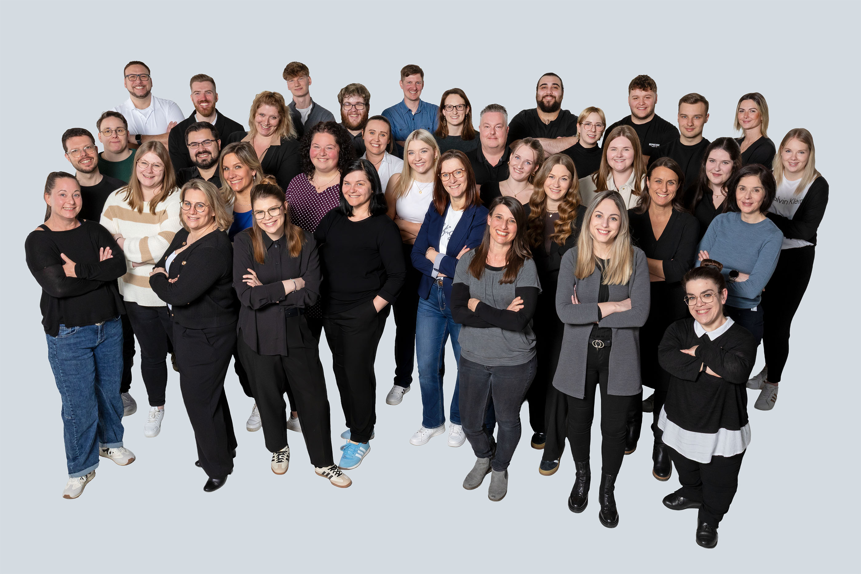 Team der marcapo Marketingberatung, rund 50 Mitarbeitende in mehreren Reihen vor hellgrauem Hintergrund
